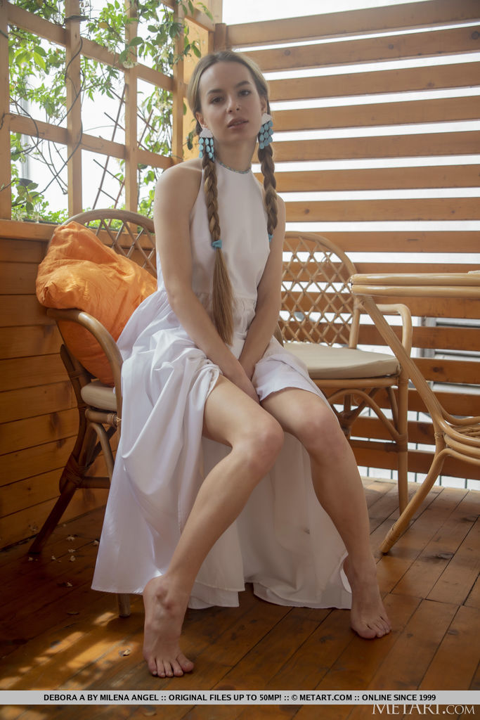 A slim blonde with two long braids and a white dress